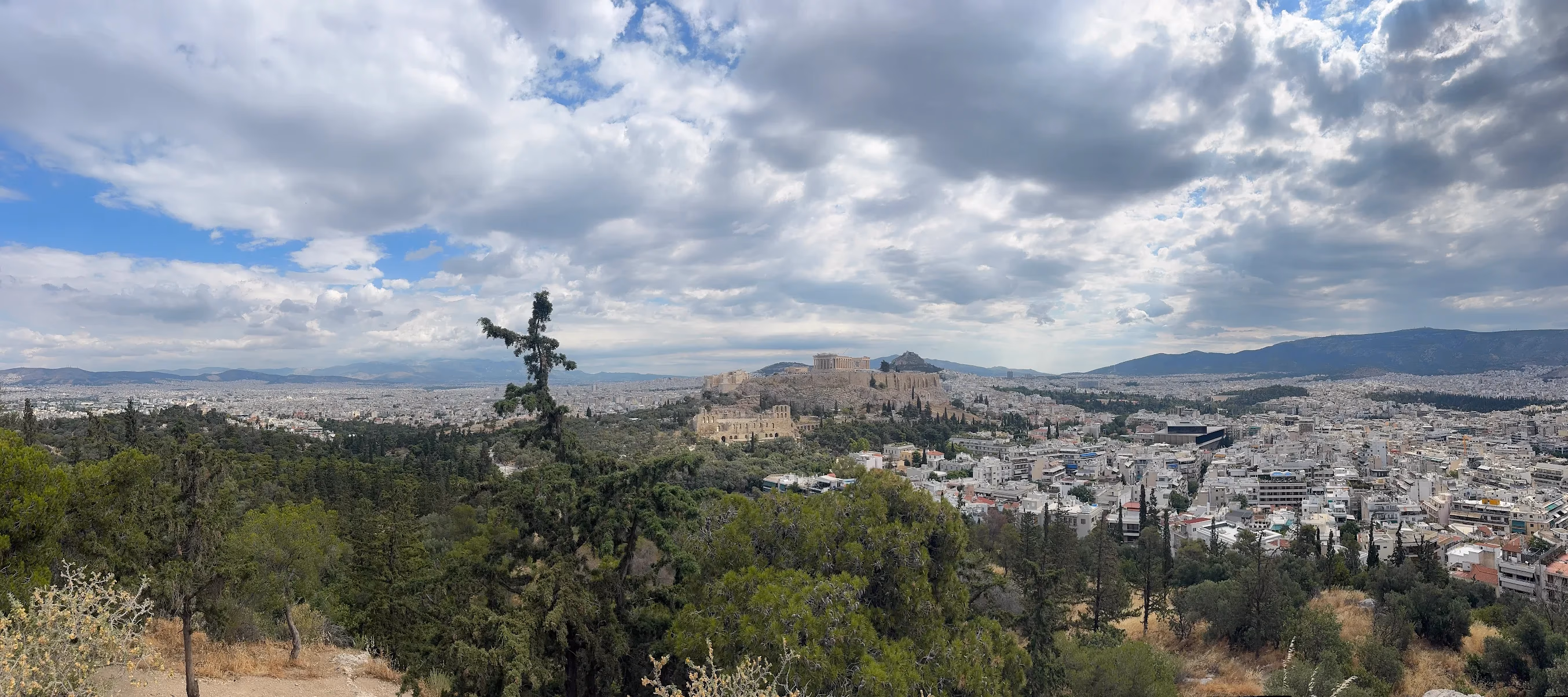 Wide daytime panorama over Athens showing both the Acropolis and Lycabettus Hill, the whole walking tour route