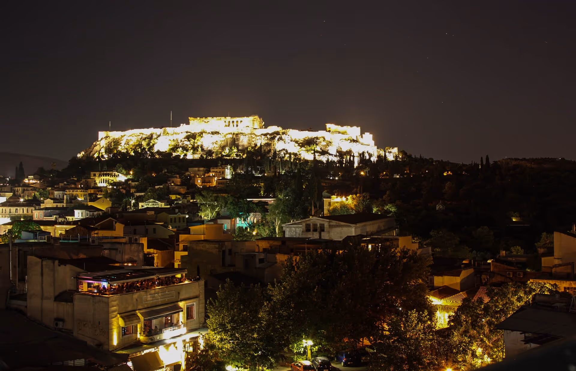 Pella Inn rooftop view of the illuminated Acropolis at night